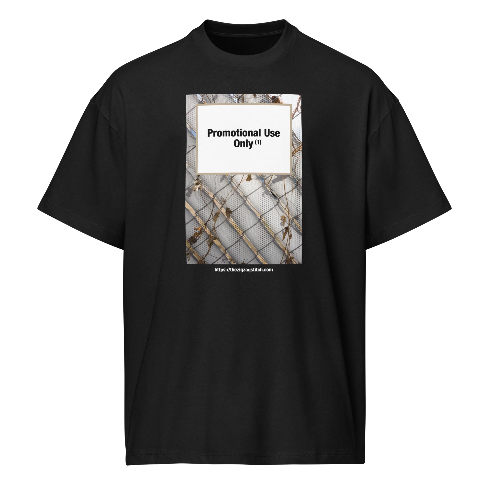 Black graphic t-shirt featuring a print of a chain-link fence with dried vines. Centered text block reads “Promotional Use Only” designed by The Zigzag Stitch.