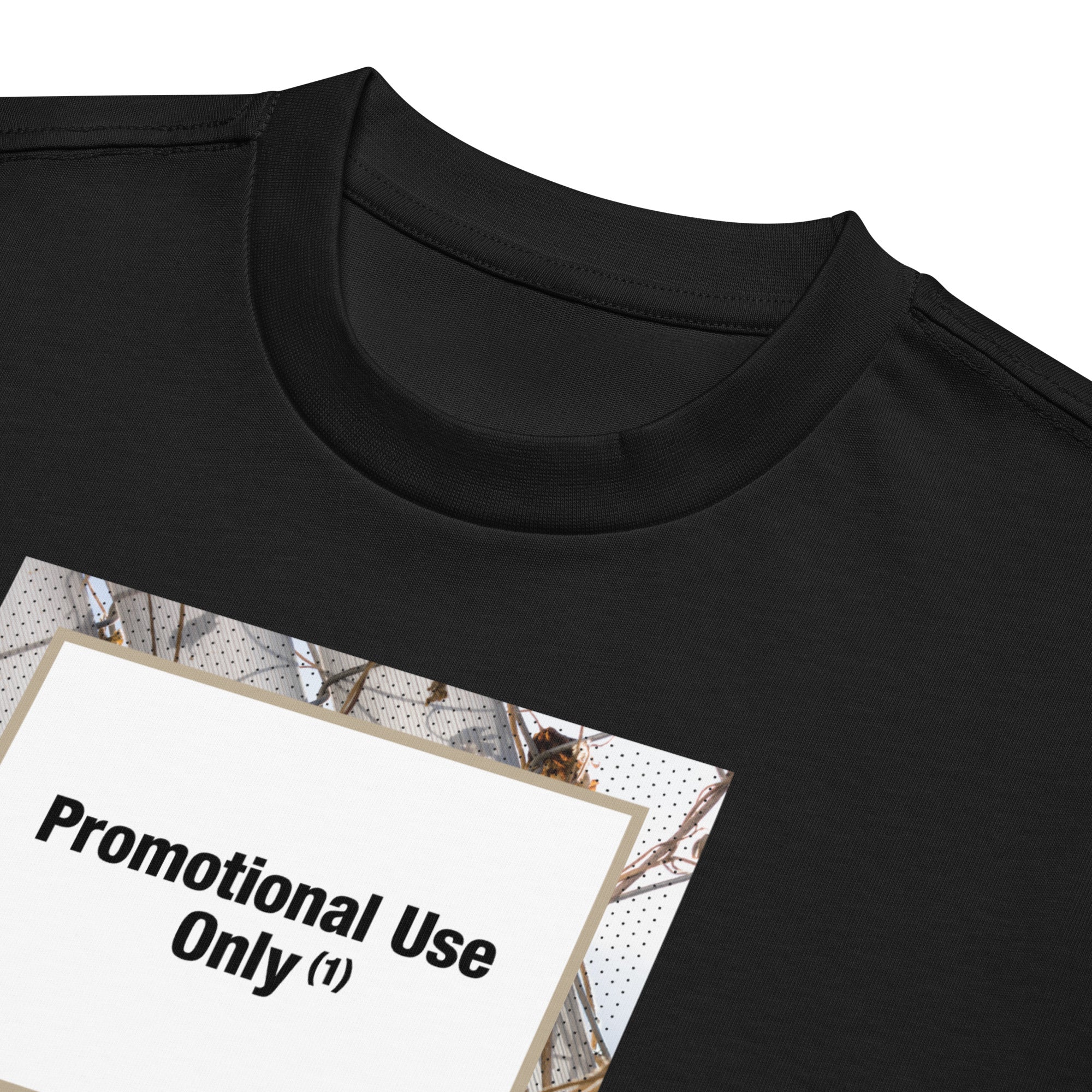 Black t-shirt with graphic print of a chain-link fence covered in dried vines. Reads “Promotional Use Only” designed by The Zigzag Stitch