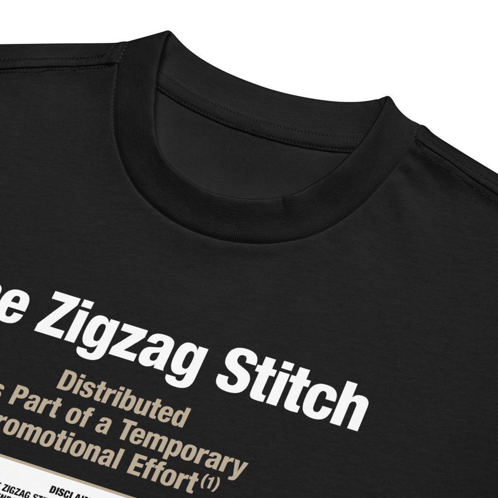 Detail view of black t-shirt with graphic print. Reads “Distributed as Part of a Promotional Effort” designed by The Zigzag Stitch