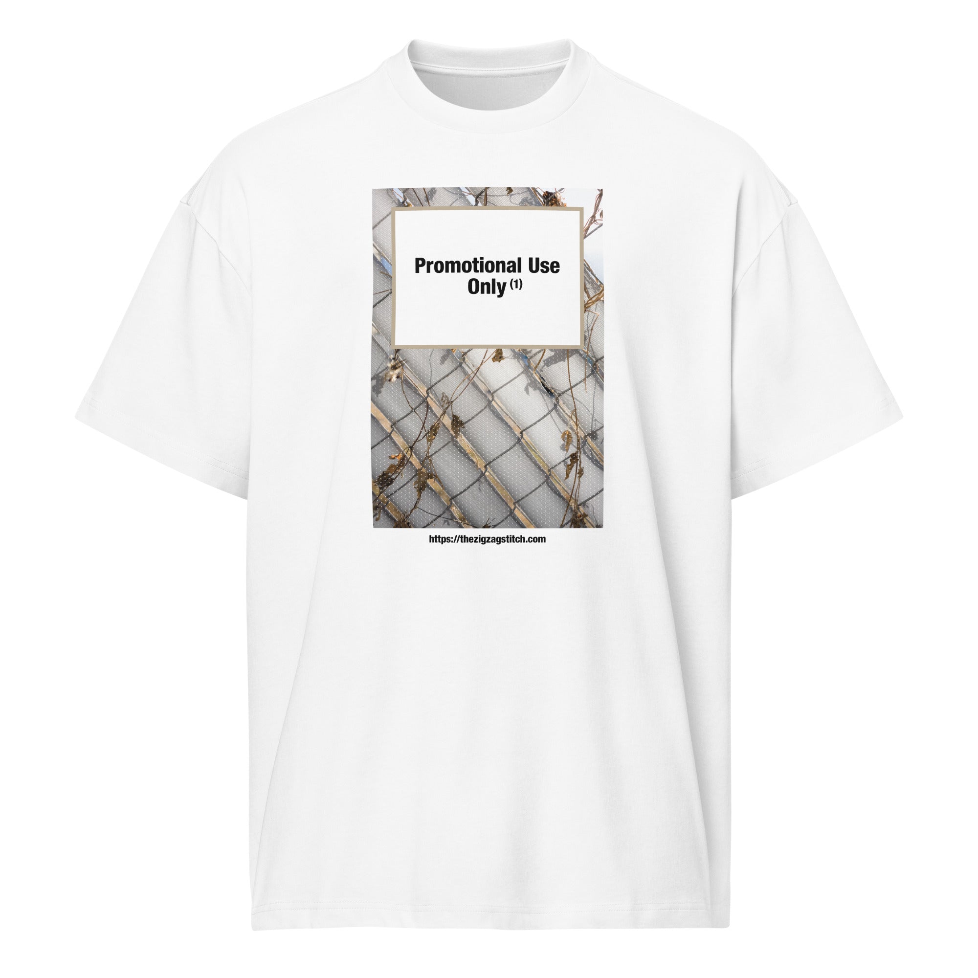 White graphic t-shirt featuring a print of a chain-link fence with dried vines. Centered text block reads “Promotional Use Only” designed by The Zigzag Stitch.