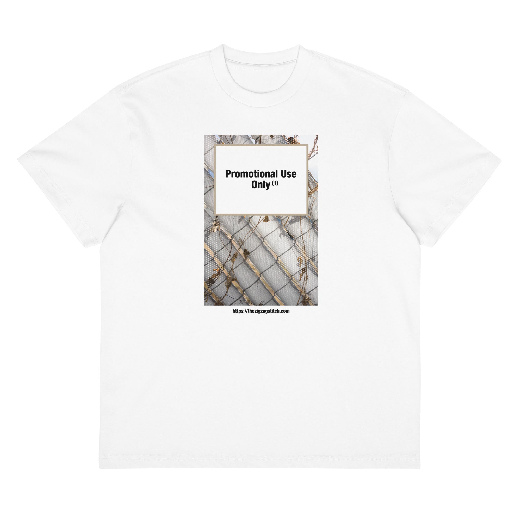White t-shirt with graphic print of a chain-link fence covered in dried vines. Reads “Promotional Use Only” Designed by The Zigzag Stitch